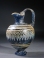 Eastern Mediterranean blue core form glass oinochoe with yellow and turquoise ornament.