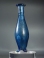 Early Roman blue glass unguentarium (cosmetic flask) with three pinched feet.