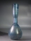 Roman light blue glass bottle with ribbed body and trailed neck.