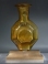 Sidonian golden yellow glass faceted flask with two handles.