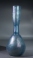 Roman light blue glass bottle with ribbed body and trailed neck.