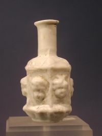 Sidonian mold blown opaque white glass flask with masks