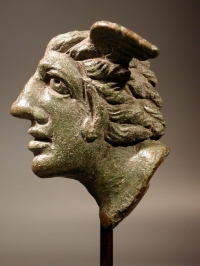Roman bronze applique winged head of a man with pointed ears.