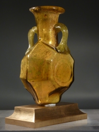 Sidonian golden yellow glass faceted flask with two handles.