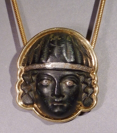 Early Roman bronze applique head of a woman with silver eyes and diadem, set in modern 18k gold setting.