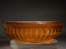 Early Roman golden-amber glass ribbed bowl.