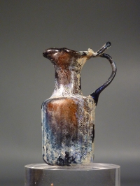 Roman amber glass juglet with trefoil mouth and ribbed body.
