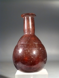 Early Roman amethyst purple glass unguentarium (cosmetic flask).