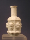Sidonian mold blown opaque white glass flask with masks