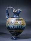 Eastern Mediterranean blue core form glass oinochoe with yellow and turquoise ornament.