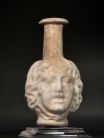 Roman molded opaque white glass Medusa Janus head flask.