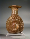 Roman yellowish green glass Janus head flask.